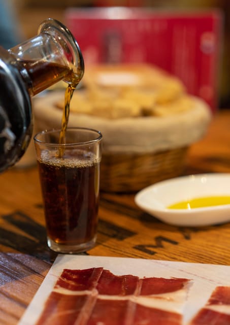 Málaga: Wine & Tapas Tour - Iberian ham, olives, and the family-run grocery stop